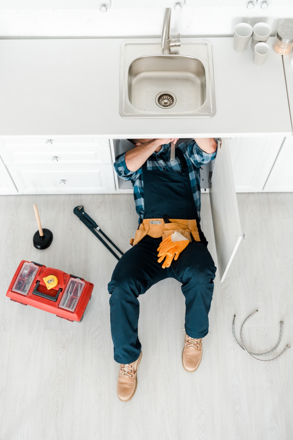 Plumber working underneath a kitchen sink